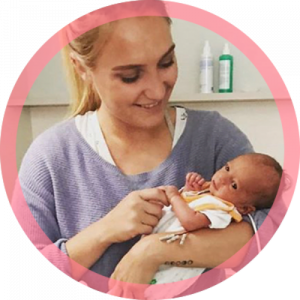 hebamme vivian hält lächelnd ein baby